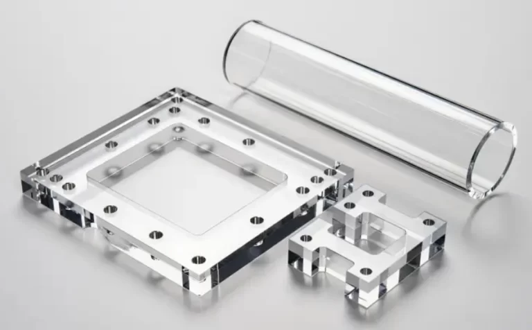 Clear CNC-machined acrylic (PMMA) parts, including a frame and a tube