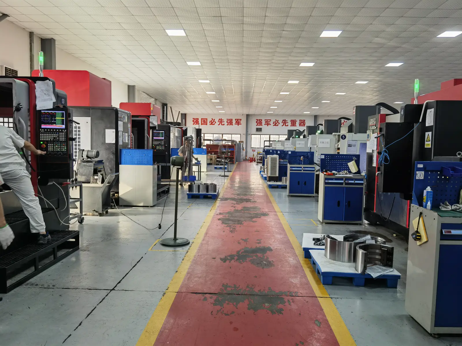 Gang zwischen den Reihen der CNC-Bearbeitungszentren auf dem Prolean-Werkstattboden
